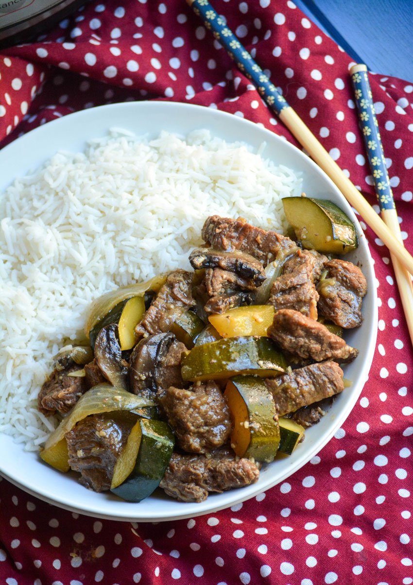 Instant Pot hibachi style steak & zucchini served with steamed white rice in a shallow white bowl