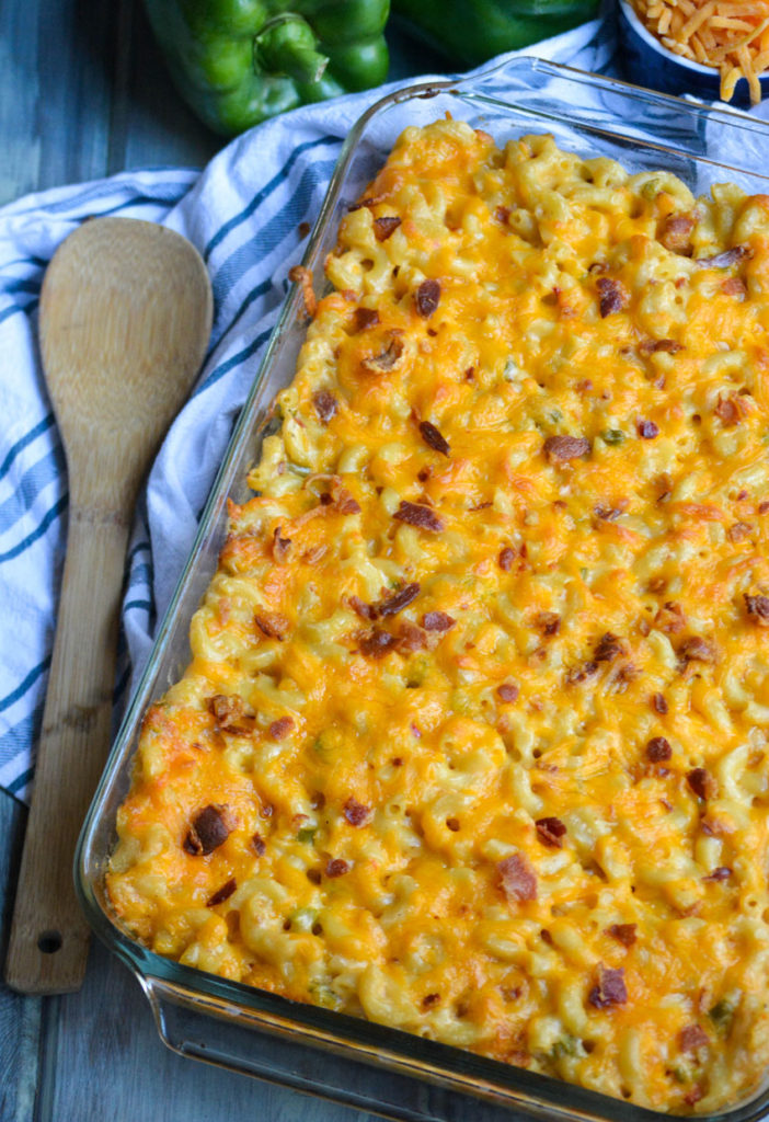 a casserole dish filled with baked pimento cheese macaorni & cheese topped with crisp bacon bits
