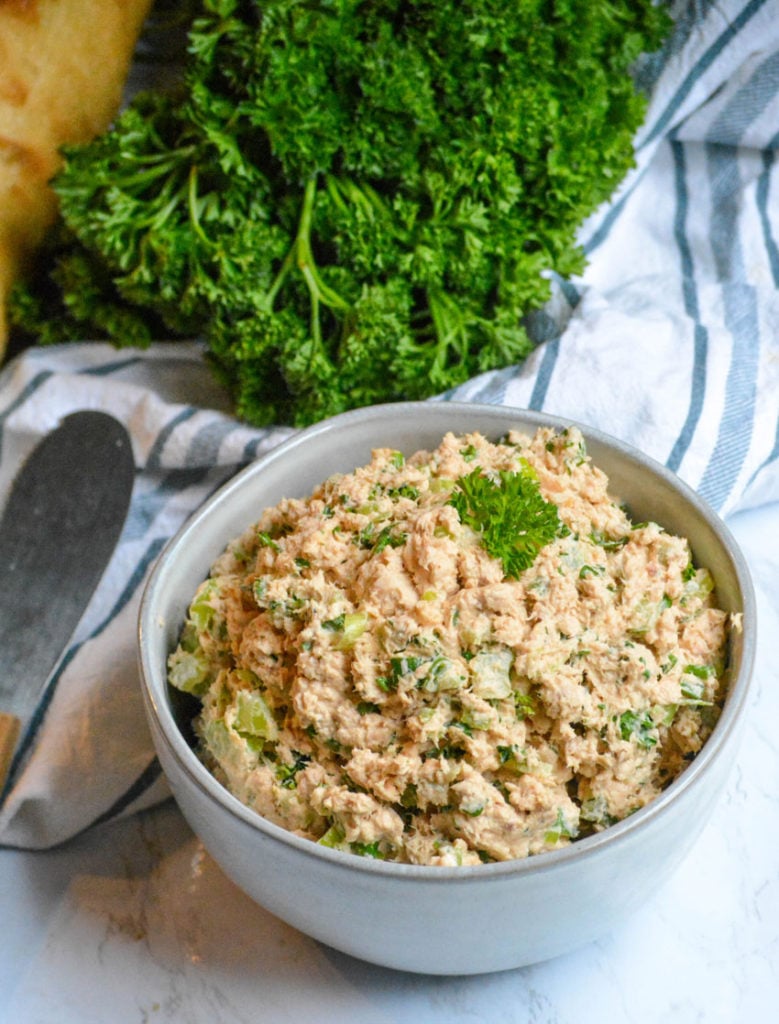 salmon salad spread shown in a gray bowl with fresh parsley in the background