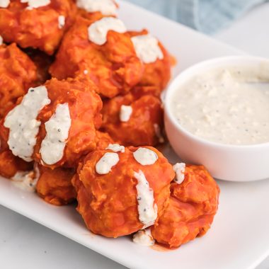 buffalo chicken meatballs on a white platter with a bowl of blue cheese dressing