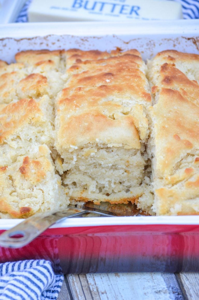 golden brown butter swim biscuits in a red square baking dish