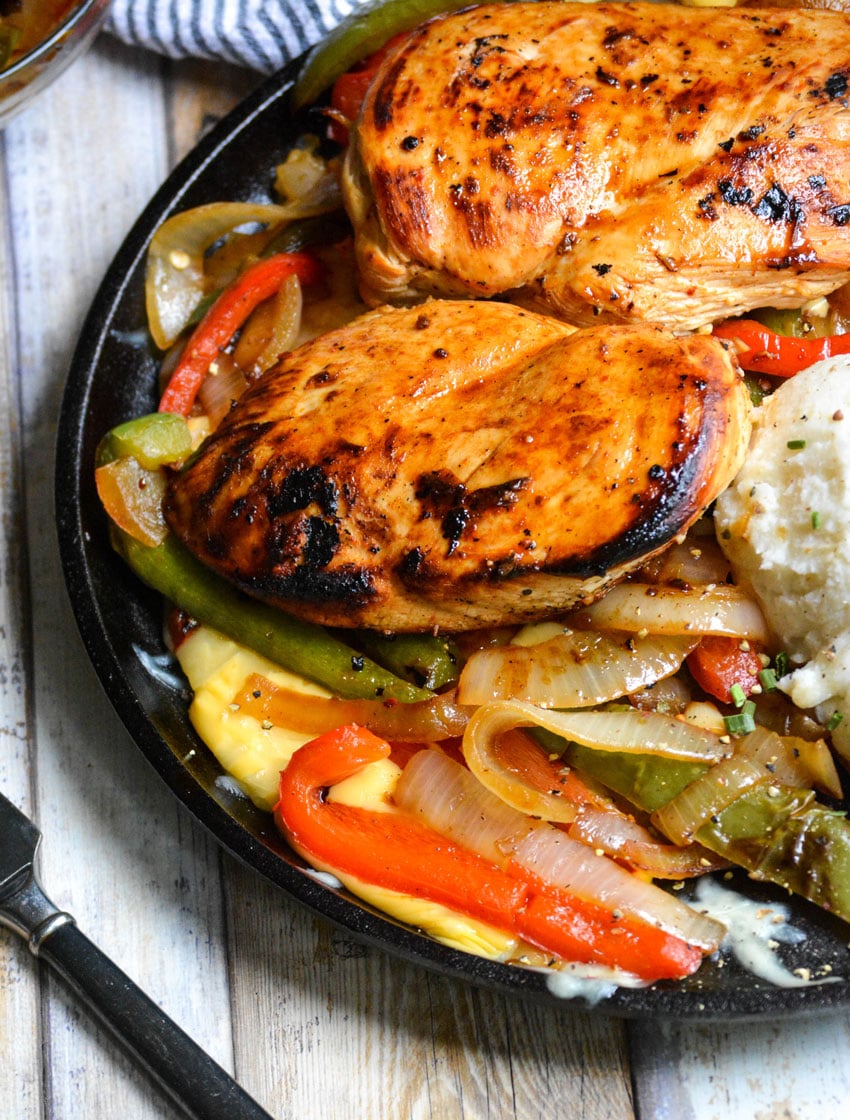 copycat TGIFriday's sizzlin chicken & cheese on a flat cast iron skillet