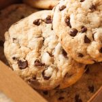 the best homemade chocolate chip cookies in a brown cardboard bakery style dessert box