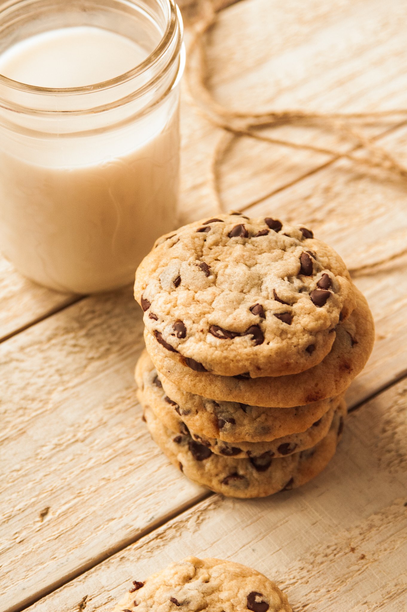 a stack of the best homemade chocolate chip cookies in front of a glass of milk
