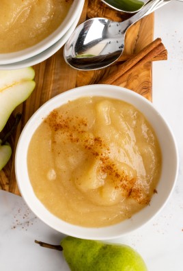 Instant pot pear sauce served in a white bowl & sprinkled with ground cinnamon