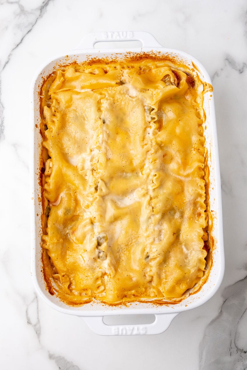 a baked creamy cajun lasagna in a white casserole dish