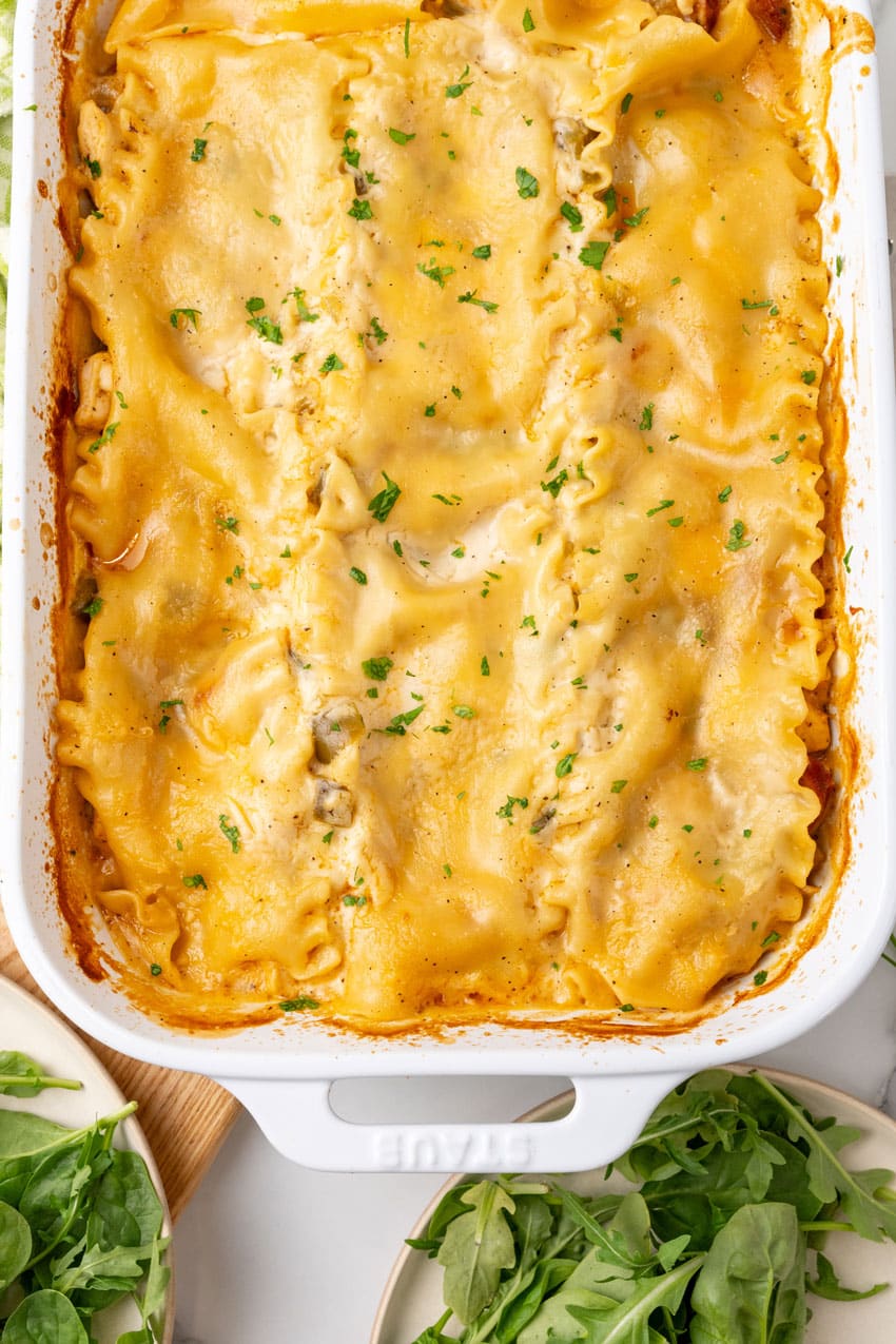 a baked creamy cajun lasagna in a white casserole dish