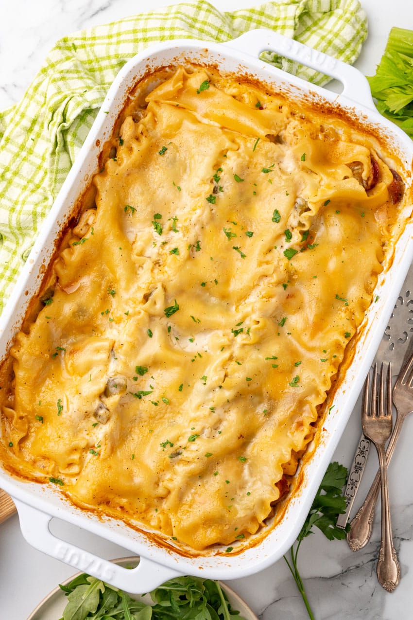 a baked creamy cajun lasagna in a white casserole dish