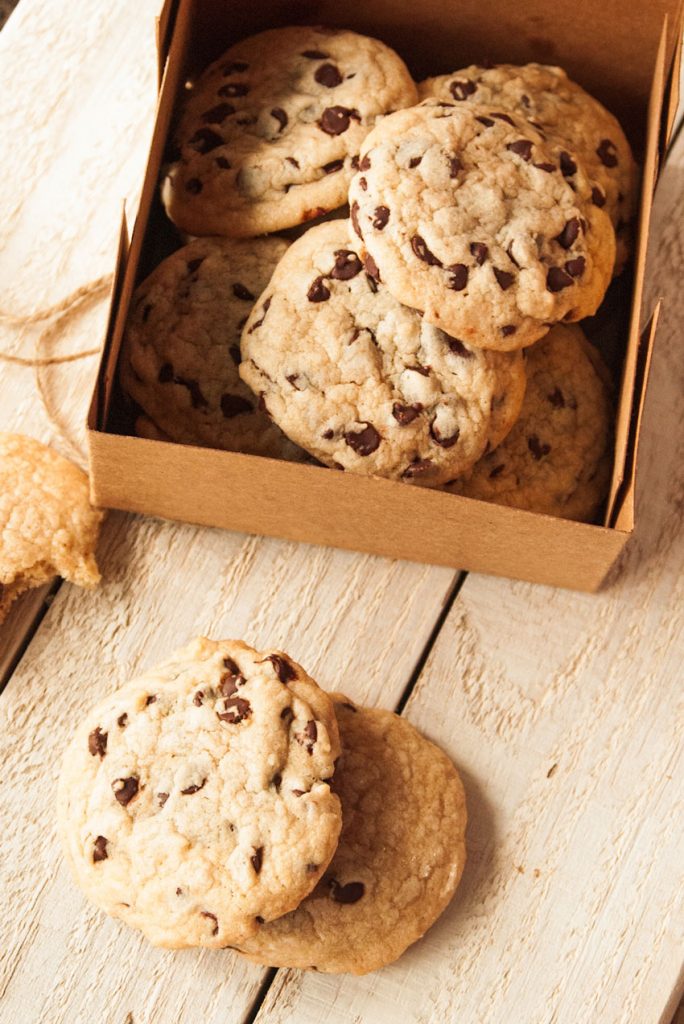 the best homemade chocolate chip cookies in a brown cardboard bakery style dessert box