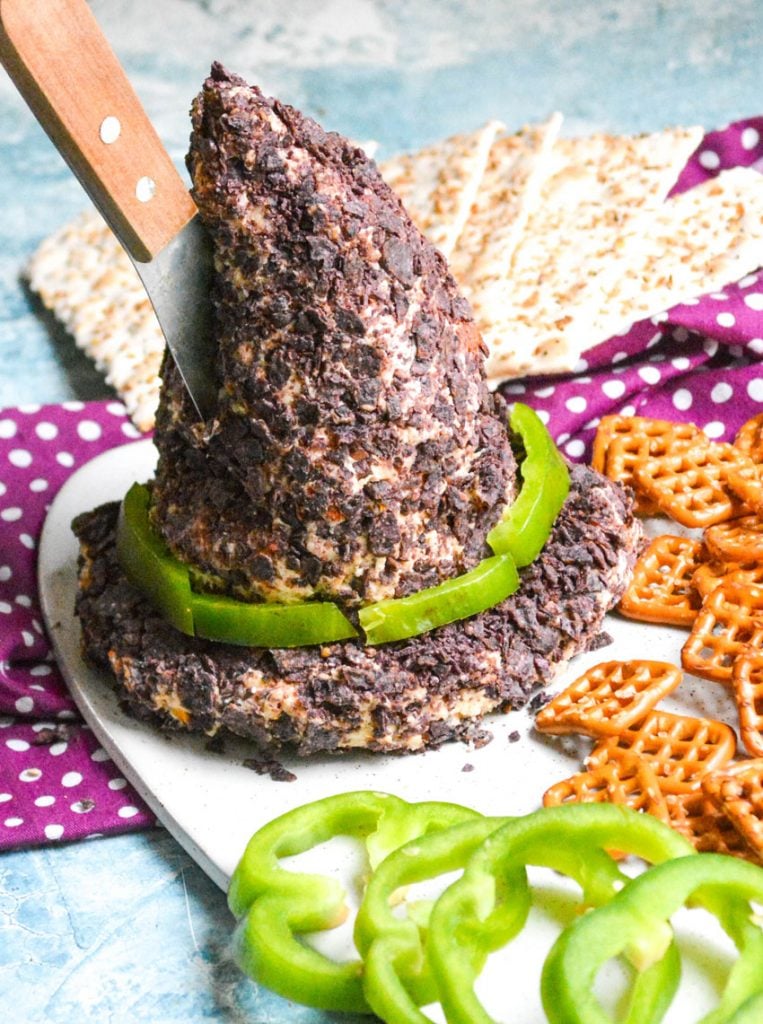 witch's hat cheese ball with a wooden handled spreader sticking out the side