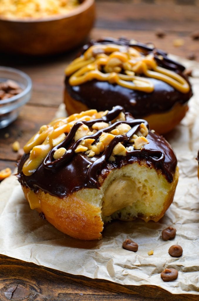 peanut butter stuffed reese's donuts bitten to reveal the peanut butter mousse filling in the center