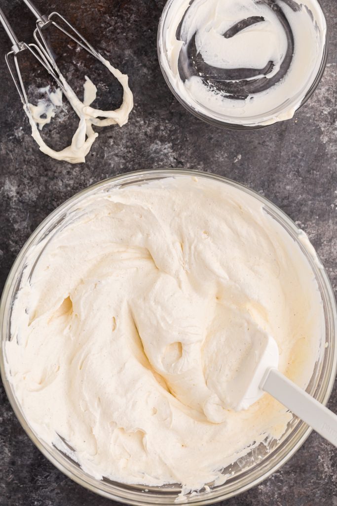 a white spatula in a glass mixing bowl filled with creamy eggnog dip