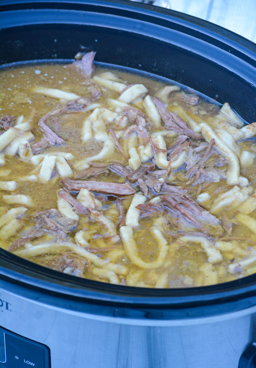 slow cooker beef & noodles in a black and silver crockpot