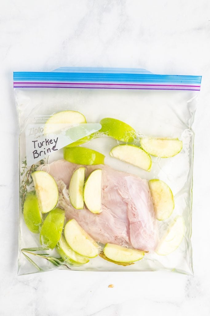 homemade turkey brine recipe and raw turkey breast sealed in a labeled, ziplocking plastic bag