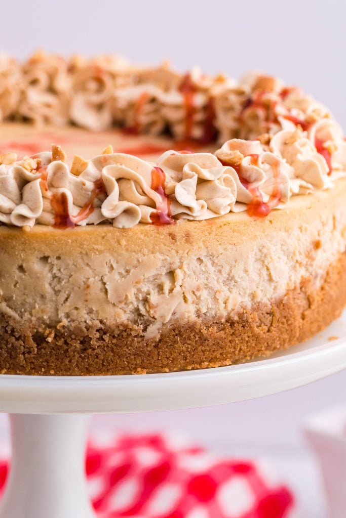 peanut butter & jelly cheesecake on a white pedestal