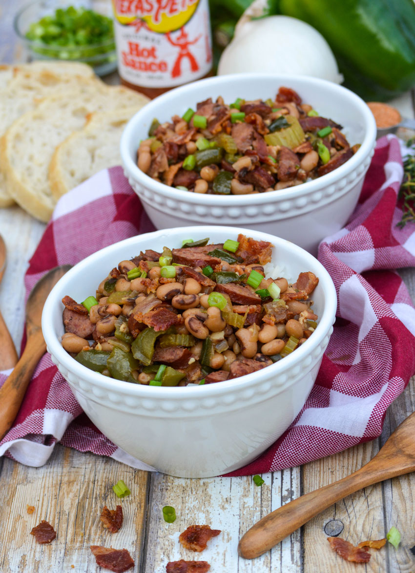 Southern hoppin john served over steamed white rice in two white bowls