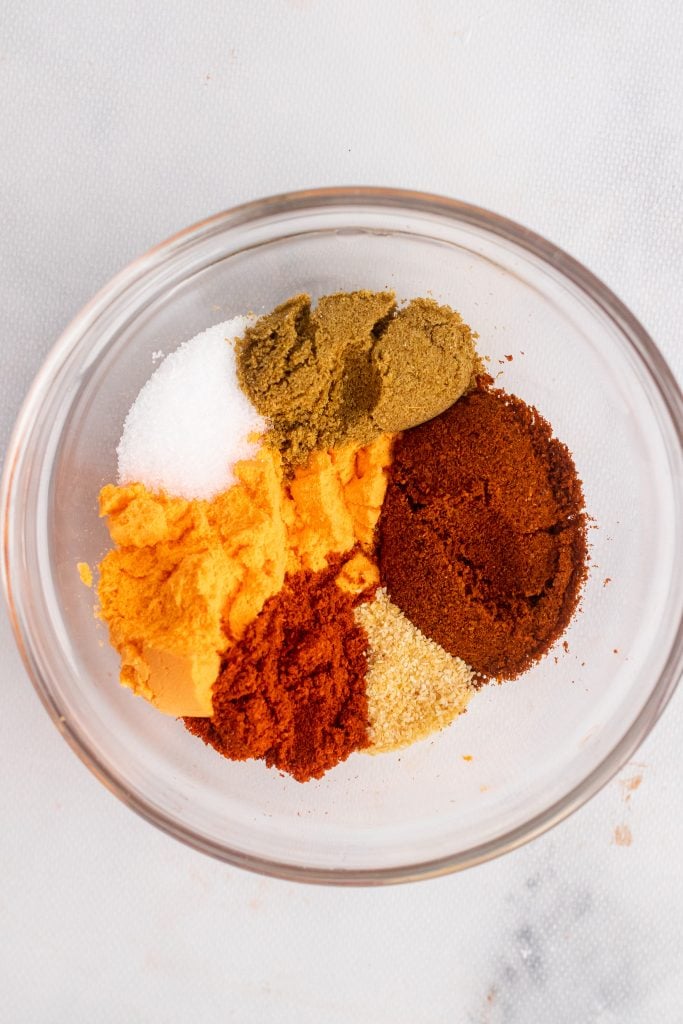 a colorful variety of seasonings in a glass mixing bowl