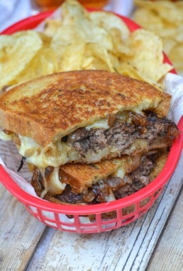 classic patty melts served with chips in paper lined red plastic fast food baskets