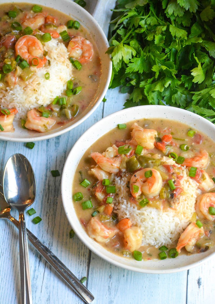 two white bowls of shrimp etouffee over mounds of steamed white rice