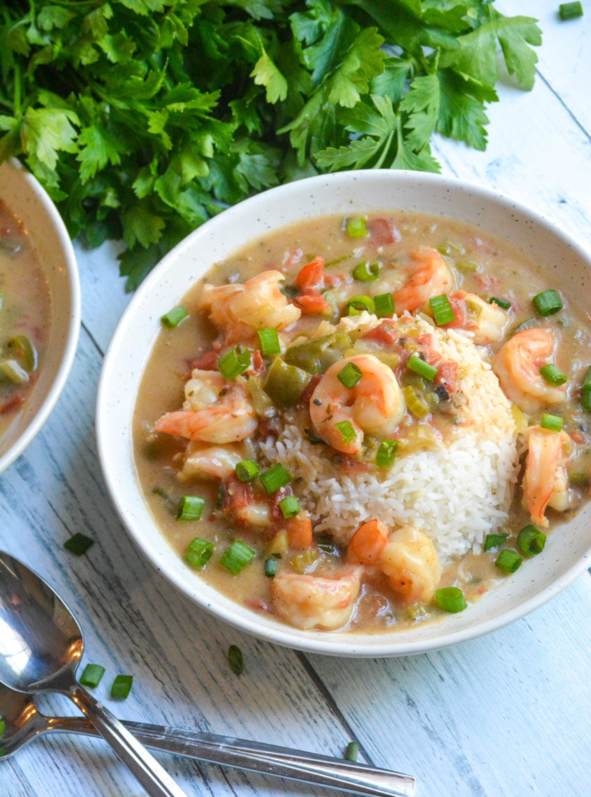 two white bowls of shrimp etouffee over mounds of steamed white rice