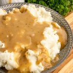 easy homemade gravy served over mashed potatoes in a gray bowl