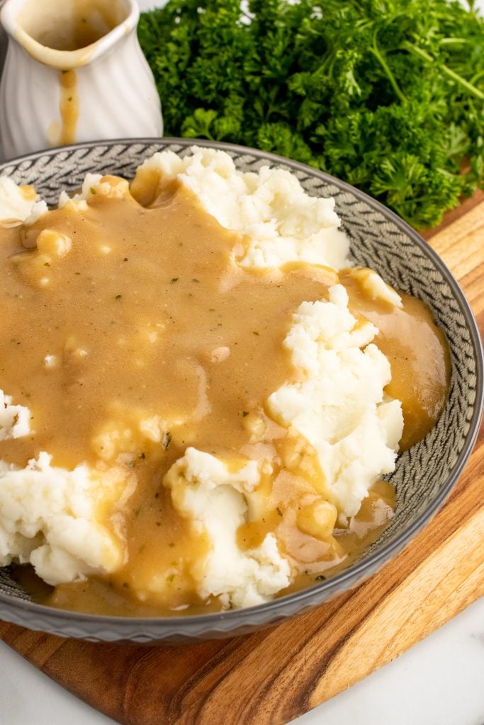 easy homemade gravy served over mashed potatoes in a gray bowl