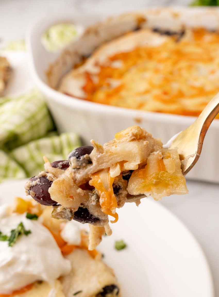 a golden fork lifting up a scoop of cheesy chicken tex mex lasagna
