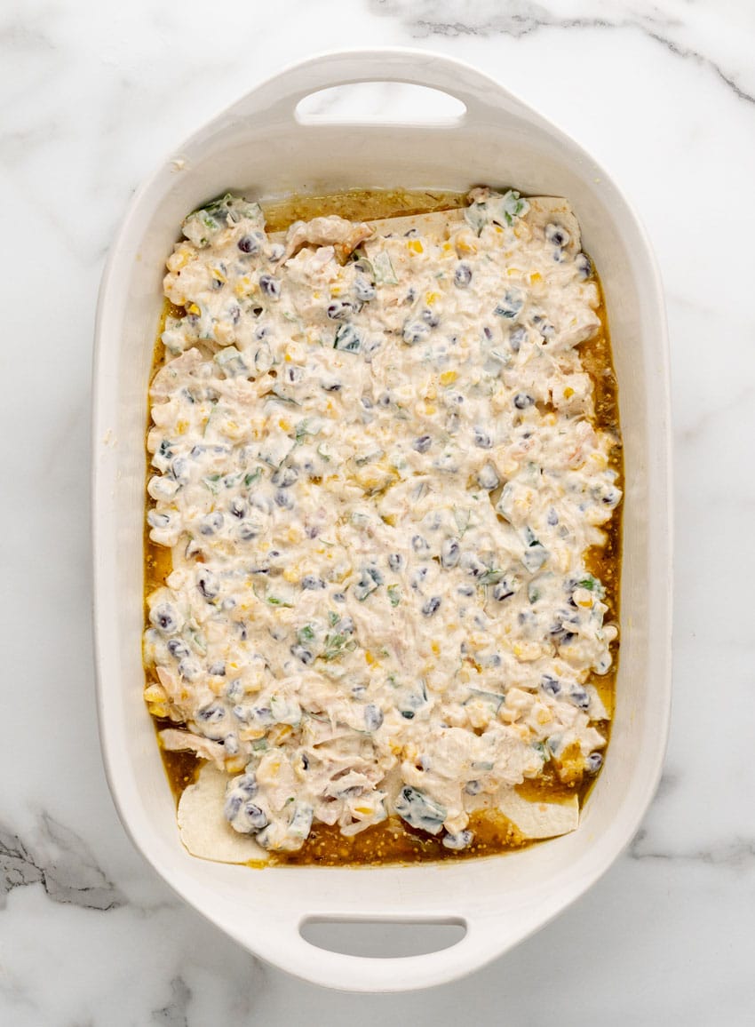 tex mex layered chicken casserole in a white baking dish