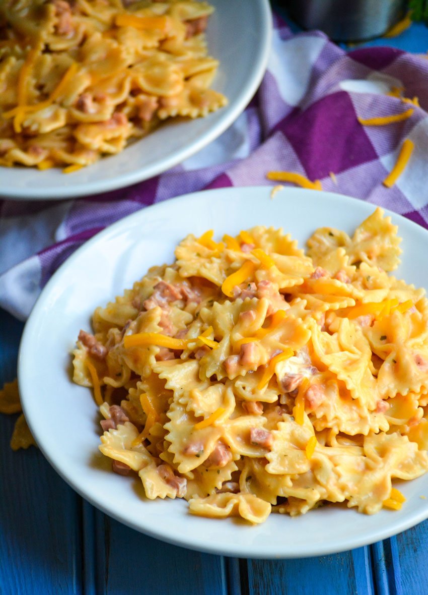 two white bowls filled with cheesy Instant Pot crack pasta with ham