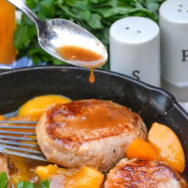 a spoon dripping juices over the meat in this peaches and pork chop skillet