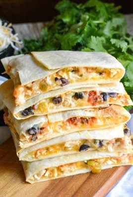 a stack of sheet pan chicken quesadillas on a wooden cutting board