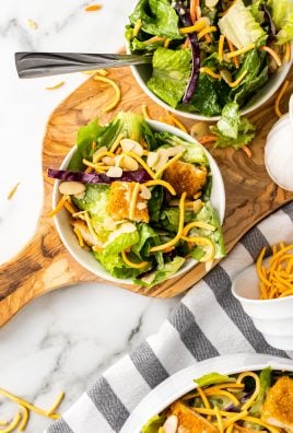 copycat Applebee's oriental chicken salad on two white plates on a wooden cutting board