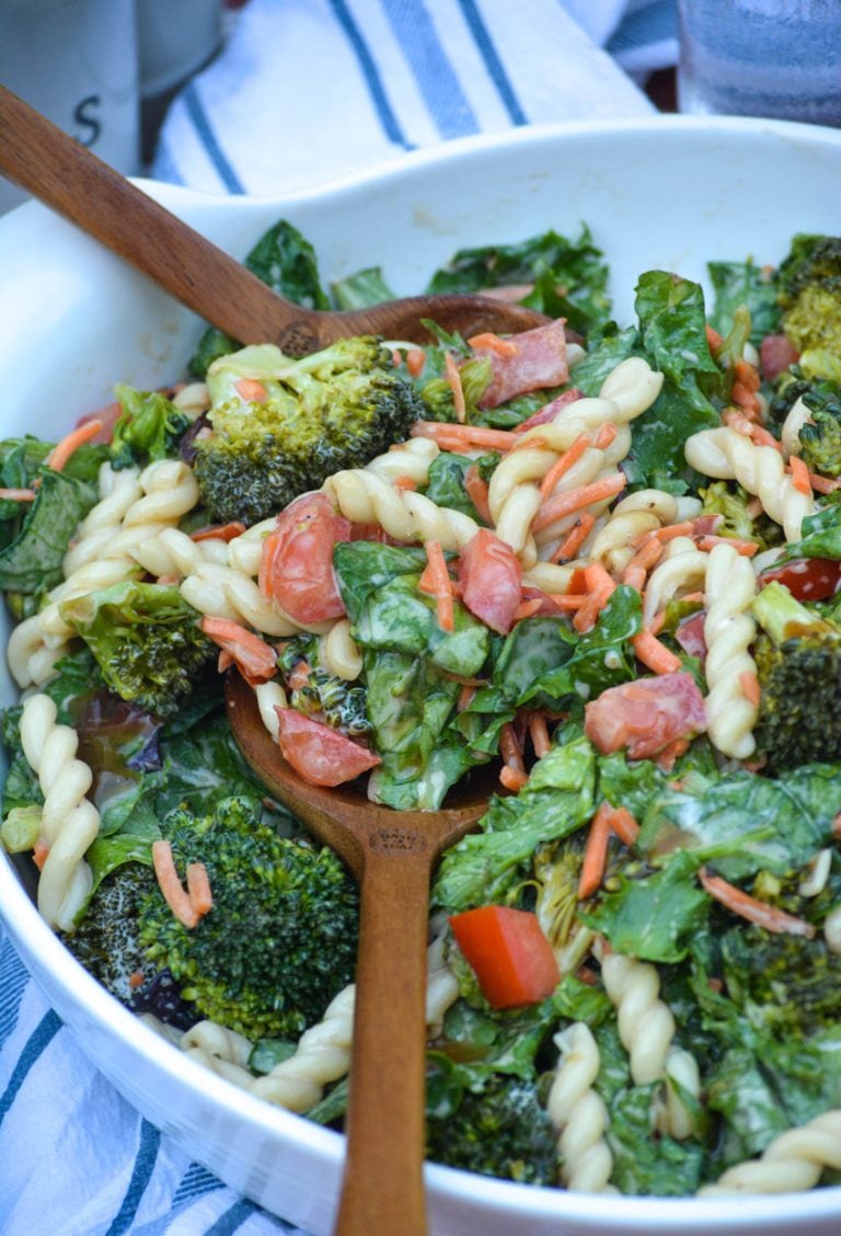 balsamic salad with pasta in a white bowl with wooden salad tongs