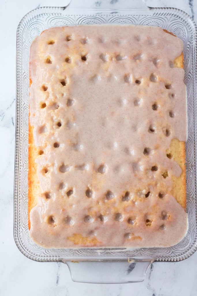 cinnamon filling spread over a cooled cake with holes poked in it