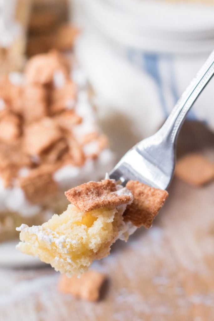 a silver fork holding up a piece of cinnamon toast crunch poke cake