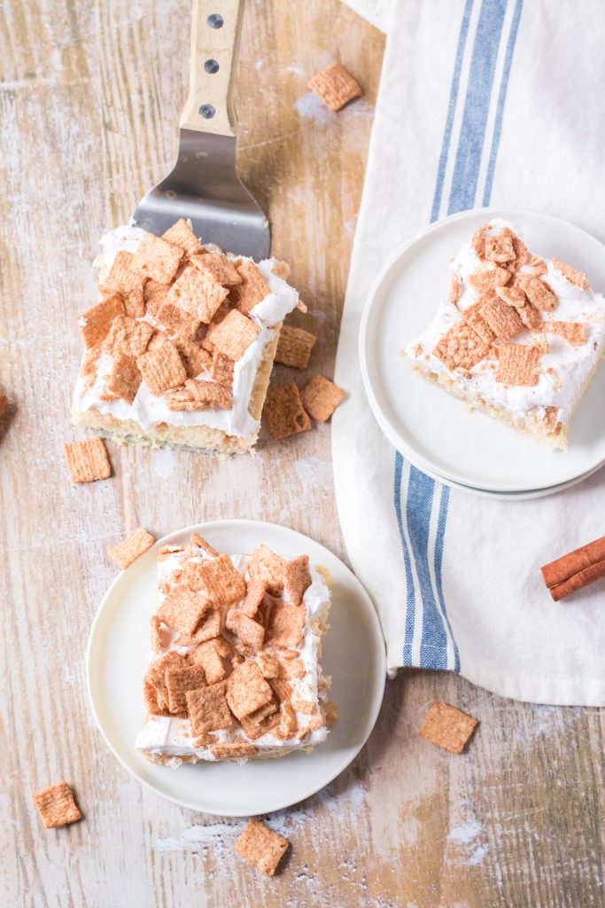 slices of cinnamon toast crunch poke cake on small white plates