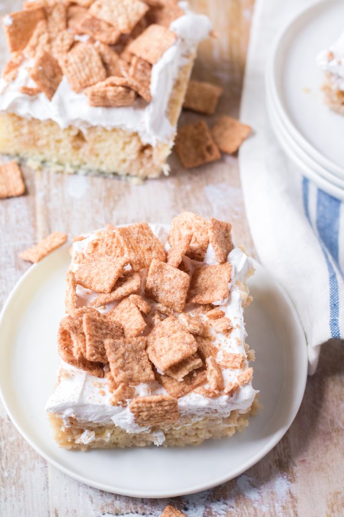 a slice of cinnamon toast crunch poke cake on a small white plate