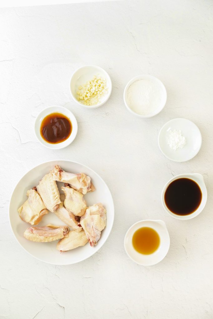 an overhead image showing the measured ingredients needed to make a batch of spicy asian chicken wings in the air fryer