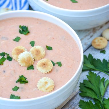 easy crab bisque in two white bowls topped with fresh herbs and oyster crackers