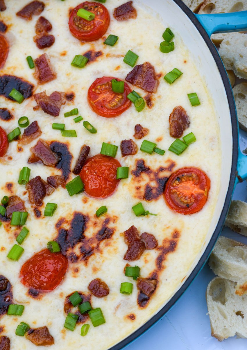 baked Kentucky hot brown dip topped with crisp pieces of bacon, sliced cherry tomatoes and green onions pieces