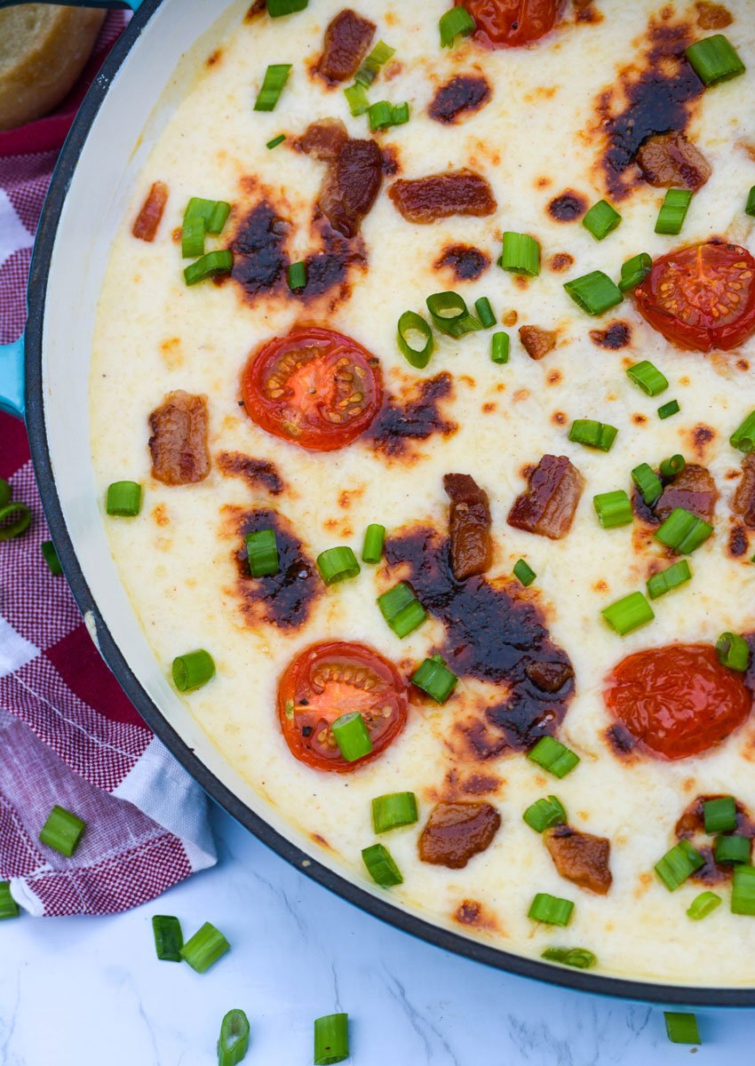 baked Kentucky hot brown dip topped with crisp pieces of bacon, sliced cherry tomatoes and green onions pieces