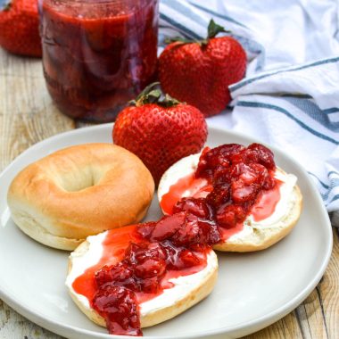 fresh strawberry sauce spread over cream cheese covered bagels on a gray plate