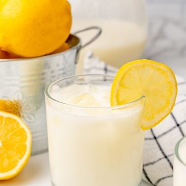creamy lemonade in glasses garnished with sliced lemon