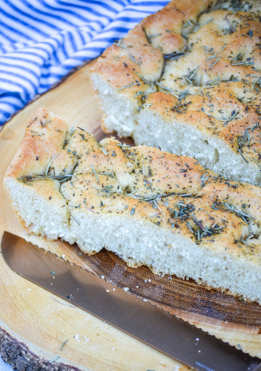 quick and easy focaccia bread topped with rosemary on a wooden cutting board