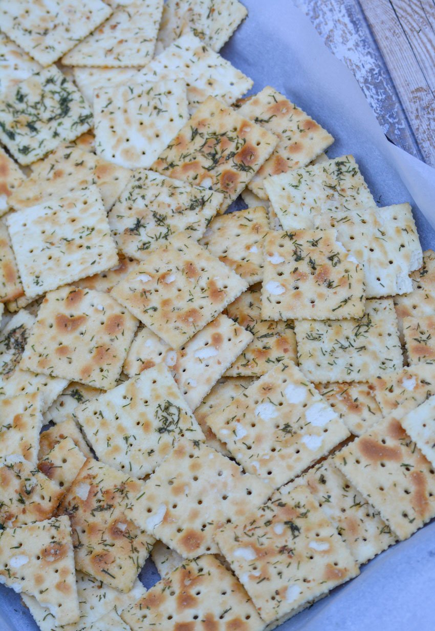 dill pickle seasoned saltine crackers on a parchment paper covered baking sheet