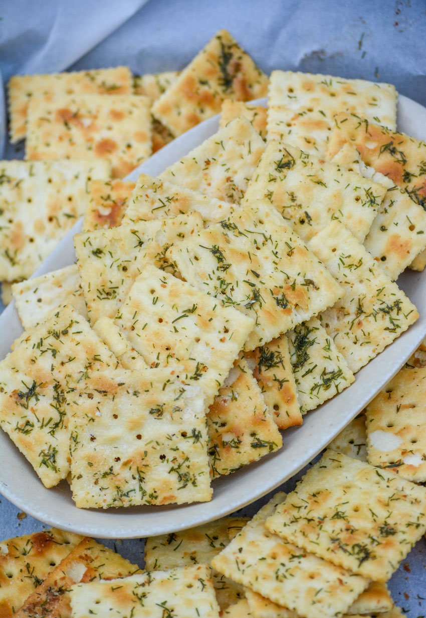 dill pickle saltine crackers on a shallow platter surrounded by more seasoned crackers