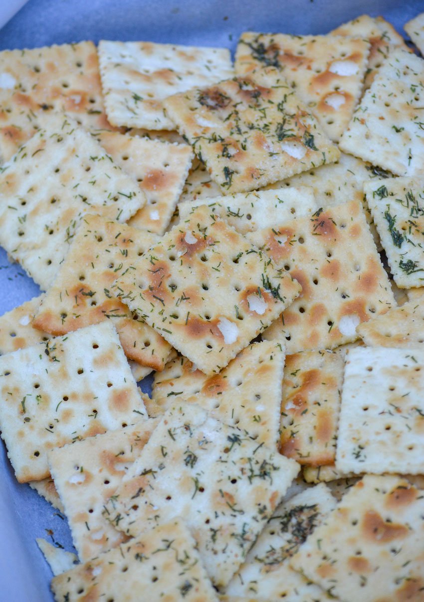 dill pickle seasoned saltine crackers on a parchment paper covered baking sheet