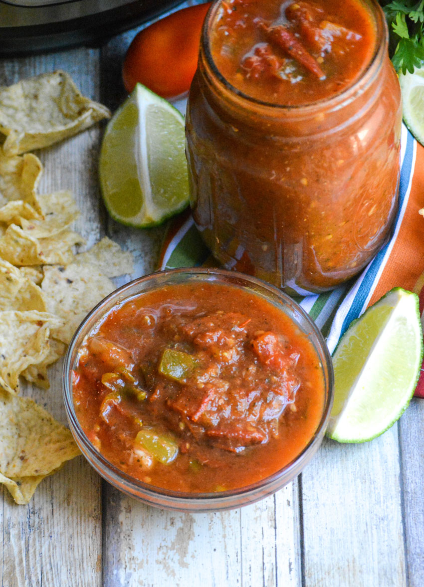 fresh instant pot salsa in a small glass dipping bowl with chips and lime wedges on the side