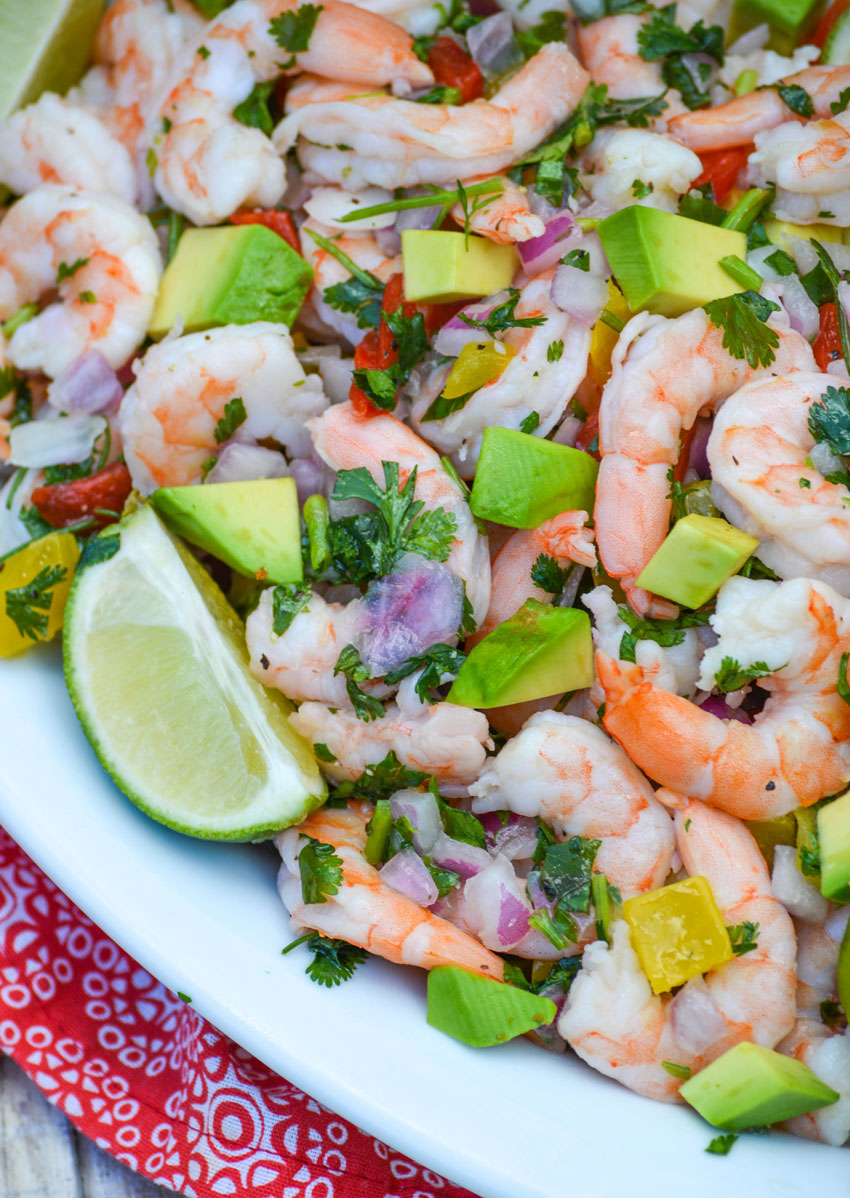 easy shrimp ceviche in a white bowl with fresh lime wedges