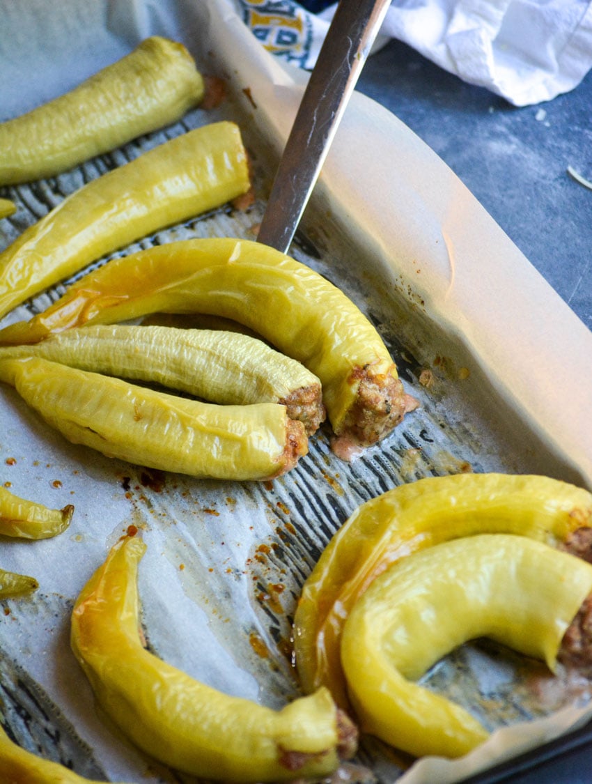 baked Italian stuffed banana peppers on a parchment paper lined baking sheet